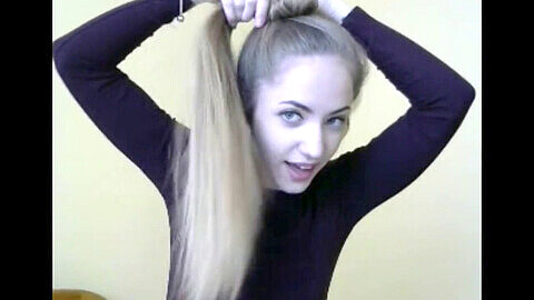 Una rubia súper sexy con cabello largo y exuberante se muestra en la webcam.