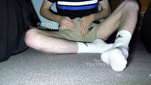 Un adolescente inexperto se acaricia su gran y duro pene en calcetines blancos y pantalones cortos antes de eyacular.