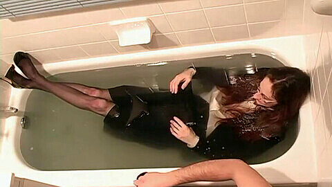 Una sexy mujercita mayor en traje de negocios se moja y se vuelve salvaje en el baño.