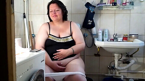 Una mujer curvilínea de talla grande hace una gran caca en el baño.