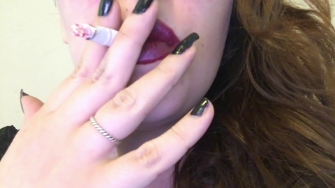Voluptuous goth babe with dark hair smokes up close - seductive dark red lipstick and black nails