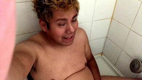 Jugendlicher Junge mit kleinem Paket wird nass und wild in der Dusche, während er pinkelt