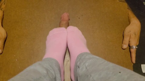 Lindos pies en calcetines rosas pisoteando y recibiendo un tratamiento duro como la roca