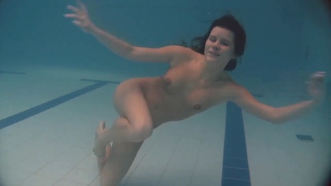 Hermosas chicas disfrutan chapoteando y nadando desnudas bajo el agua.