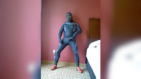 Exhibicionista en un apartamento de hotel gay se complace a sí mismo usando botines de fútbol naranjas de adidas.