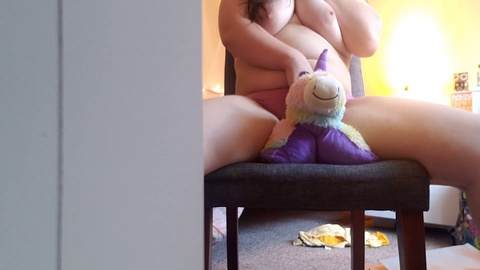 Una chica cachonda con culo blanco y grande monta un peluche de unicornio y se frota el clítoris hasta tener un orgasmo húmedo a través de sus bragas.