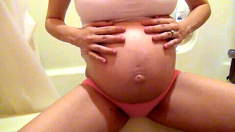 Massage du ventre de femme enceinte sous la douche avec gros seins naturels bien visibles