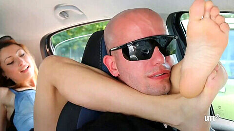 Chica italiana domina la garganta de un hombre con sus lindos pies en un coche travieso