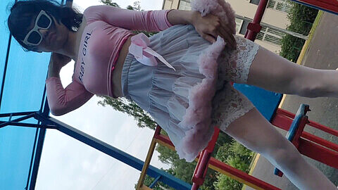 Sissy Ponyboy rosa posando en medias sexys y saltando en la cámara en público