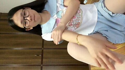 Chica asiática juega con juguete sexual sobre su coño caliente en la cámara