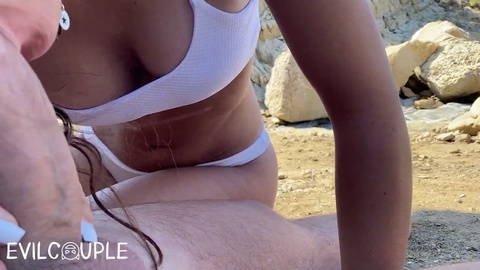 Pareja candente se entrega a un apasionado sexo al aire libre en una concurrida playa pública.