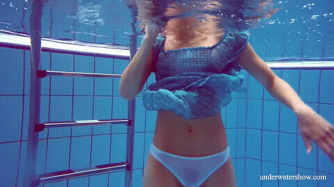 Una adolescente sexy de cabello negro y velludo disfruta de una sesión de piscina desnuda.