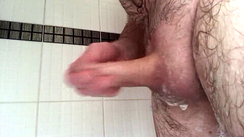 Un uomo solo si gode un intenso handjob e una sessione di tugging nella doccia