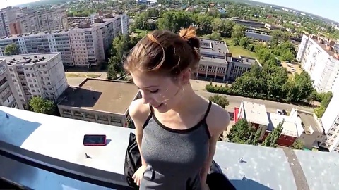 Nymphomane dénudée fait une gorge profonde à un homme sur le toit d'un immeuble à plusieurs étages